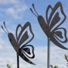 Close-up of two steel butterfly garden sculptures on stems